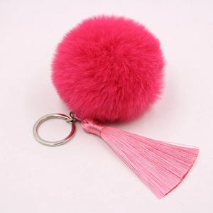 Fuchsia faux rabbit fur pompom keychain with pink tassel and silver ring on pink background