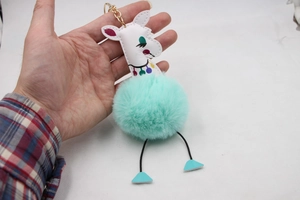 Détail d'un porte-clés alpaga en peluche vert menthe avec clip en métal doré
