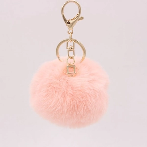 Detailed view of soft pink faux rabbit fur pompom with golden metal clasp and key ring