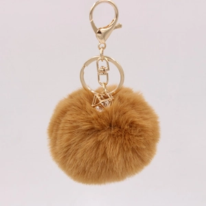 Detail of brown faux rabbit fur keychain with gold ring and crystal gem pendant