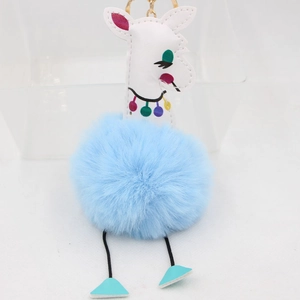 Détail du porte-clés girafe en peluche bleue avec tête en cuir et fermoir doré chic
