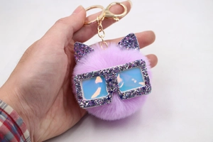 Vue détaillée du porte-clés chat en peluche violet avec oreilles pailletées et lunettes