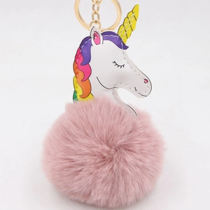 Détail d'un porte-clés licorne en fourrure rose avec fermoir doré et crinière arc-en-ciel