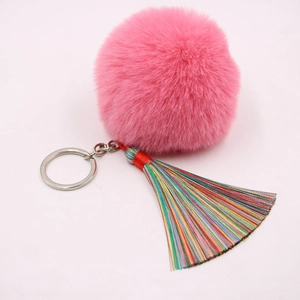 Nahaufnahme von rosa Kunstpelz-Bommel Schlüsselanhänger mit bunter Quaste und Silberring