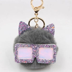 Détail de porte-clés chat en fausse fourrure grise avec lunettes à paillettes