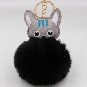 Détail d'un porte-clés chat mignon avec tête en cuir gris et pompon noir en peluche