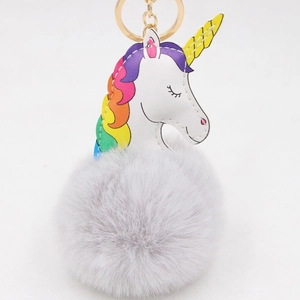 Détail d'un porte-clés licorne en peluche avec pompon gris et clip métallique doré