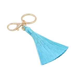 Porte-clés à pompon bleu clair avec mousqueton doré sur fond blanc pur