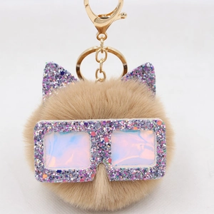 Détail de porte-clés chat en fausse fourrure kaki avec oreilles et lunettes pailletées