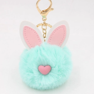 Dettaglio portachiavi a pompon verde menta con orecchie di coniglio e cuore rosa