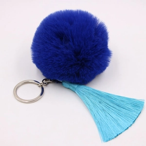 Close-up of deep blue fluffy fur pompom keychain with sky blue silk tassel and silver ring