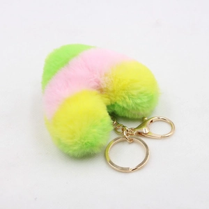 Macro detail of the colorful heart plush keychain with soft pink yellow and green faux fur