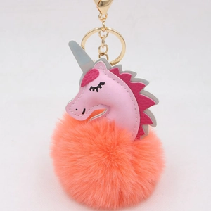 Close-up of pink unicorn pompom keychain with golden metal ring and lobster clasp