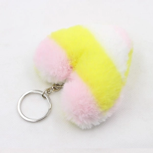 Macro shot of a colorful plush heart-shaped keychain with pink and yellow faux fur texture