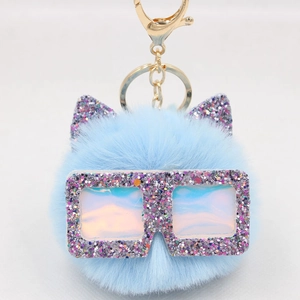 Porte-clés pompon bleu clair en fausse fourrure avec oreilles de chat et lunettes à paillettes