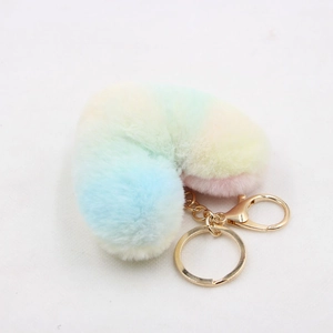 Close-up of fluffy heart-shaped plush keychain with pastel gradient stripes and gold clasp