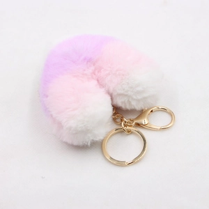 Macro shot of colorful striped faux fur plush heart keychain with golden metal clasp
