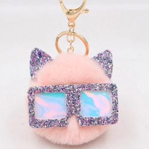 Détail du porte-clés en fausse fourrure rose avec oreilles de chat et lunettes pailletées