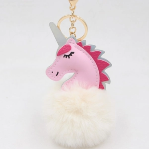 Detailed close-up of pink unicorn head with soft white pom-pom and golden keychain clip
