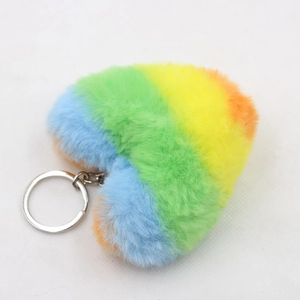 Detailed close-up of rainbow striped plush heart keychain with soft faux fur texture