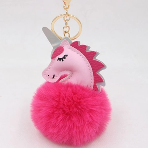 Close-up of pink unicorn plush pompom keychain with golden metal clasp and ring
