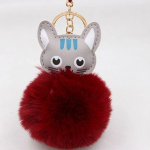 Gros plan du joli porte-clés pompon chat gris avec une chaîne en métal doré élégante