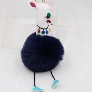 Détail du porte-clés alpaga avec pompon en peluche bleu foncé et fermoir doré chic