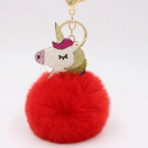 Detail of red plush unicorn keychain with gold hook and glittery unicorn head ornament