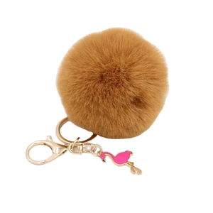 Brown fluffy pompom keychain with golden ring and pink flamingo charm on white background