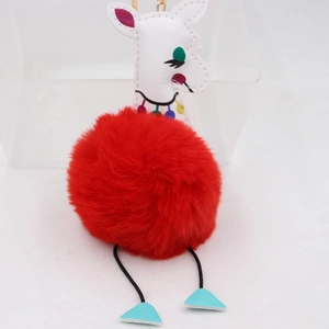 Détail du porte-clés girafe en pompon rouge avec fermoir doré et éléments en similicuir