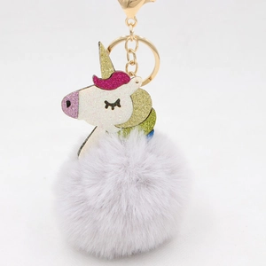 Detail of colorful unicorn keychain with glitter finish and fluffy purple faux fur pompom