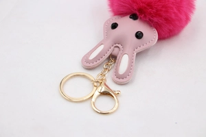 Détail d'un porte-clés lapin en peluche rose avec oreilles et fermoir en métal doré