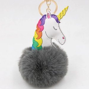 Détail du porte-clés licorne avec charme en cuir blanc et pompon en fausse fourrure grise