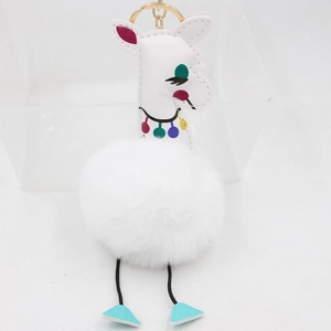 Détail du porte-clés alpaga en peluche blanche avec broderies et anneau doré brillant