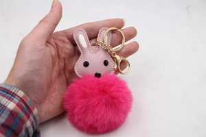 Détail d'un porte-clés lapin en simili cuir rose avec pompon en peluche magenta et fermoir doré