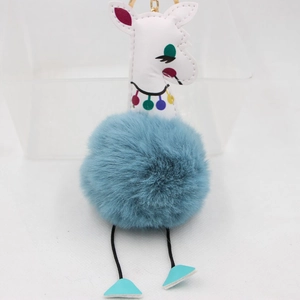Détail du porte-clés girafe pompon bleu avec tête en similicuir blanc et gland décoratif