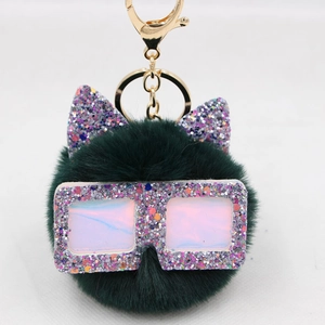 Détail du porte-clés pompon en fausse fourrure verte avec oreilles de chat pailletées