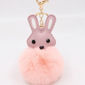 Détail d'un porte-clés lapin rose duveteux avec fermoir doré et oreilles en similicuir