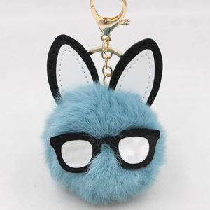 Detail of blue plush bunny keychain with black frame glasses and golden lobster clasp