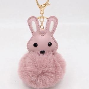Détail de porte-clés lapin en cuir PU rose avec pompon en fausse fourrure et fermoir doré