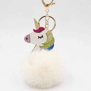 Close-up of a colorful glitter unicorn plush ball keychain with a gold metal clasp
