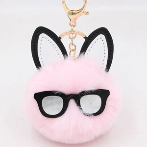 Pink faux fur bunny keychain with black glasses and gold metal hook on white background