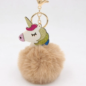 Detail of colorful glitter unicorn head and fluffy faux fur pompom keychain