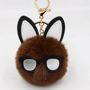 Detailed close-up of brown plush bunny keychain with rabbit ears and black glasses frame