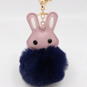 Détail du pendentif de sac avec tête de lapin rose en PU et pompon en fausse fourrure bleu