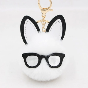 Detailed macro view of white plush pom-pom bunny keychain with black glasses and gold clasp