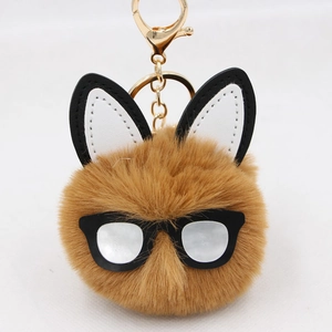 Close-up of brown plush bunny keychain with round glasses and golden metal ring clip