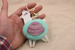 Dettaglio portachiavi alpaca con pompon verde menta e anello in metallo dorato