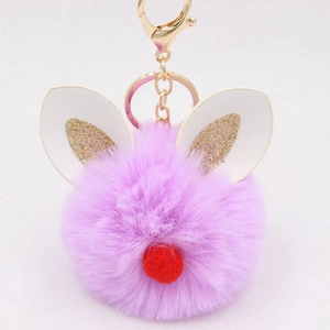 Close-up of purple faux fur keychain with bunny ears and gold lobster clasp