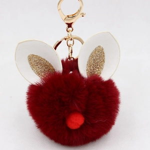 Close-up of wine red faux fur rabbit head keychain with glitter ears and golden metal clasp